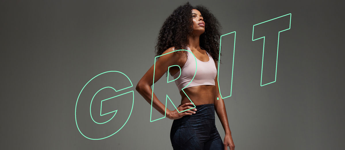athlete stand against type graphic saying grit