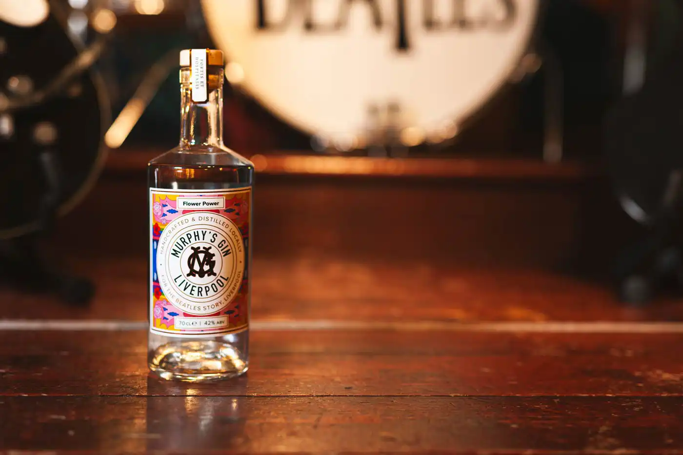 gin bottle in front of Beatles drum kit